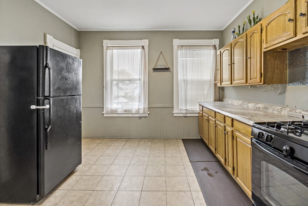 69 Locust Street New Bedford, MA 02740 - Photo 27 of 40 a kitchen with stainless steel appliances granite countertop a refrigerator and a sink