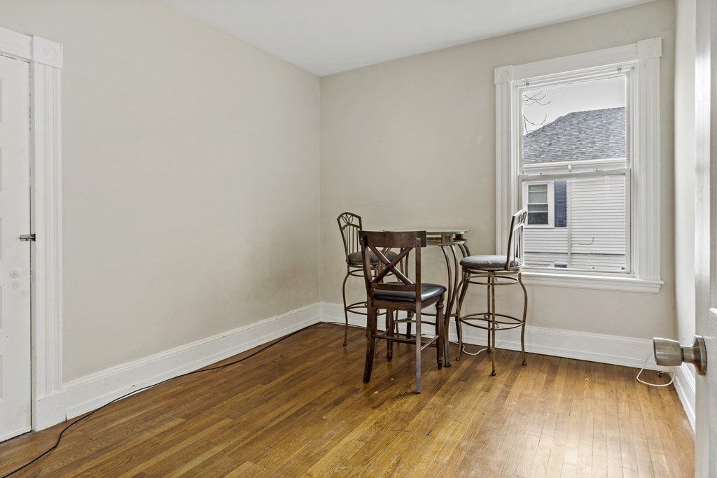 69 Locust Street New Bedford, MA 02740 - Photo 30 of 40 a view of a room with wooden floor a glass table and chair