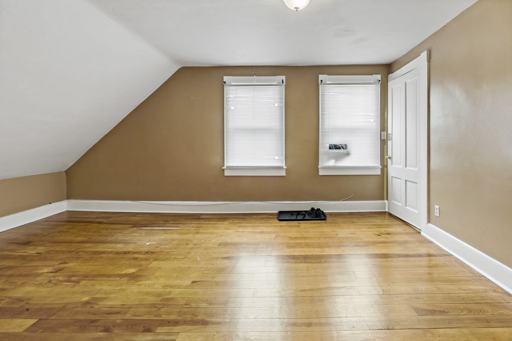 69 Locust Street New Bedford, MA 02740 - Photo 32 of 40 a view of an empty room with window and wooden floor