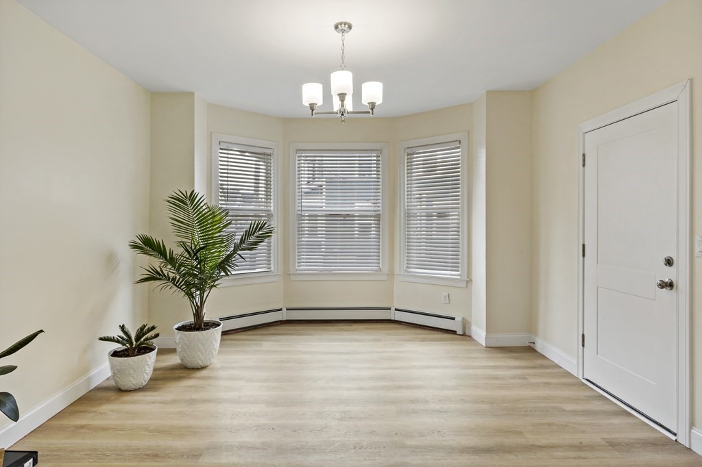 69 Locust Street New Bedford, MA 02740 - Photo 5 of 40 a view of an empty room with wooden floor and a window