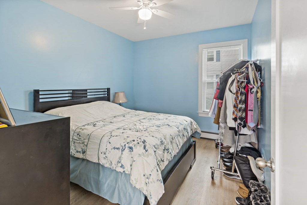 69 Locust Street New Bedford, MA 02740 - Photo 9 of 40 a bedroom with a bed and a chandelier