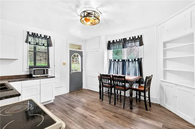 a kitchen with a white cabinets and wooden floor