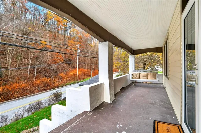 a view of a porch with a bench in the patio