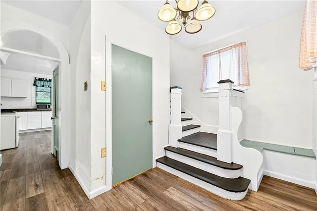 a view of a hallway with wooden floor and dining room
