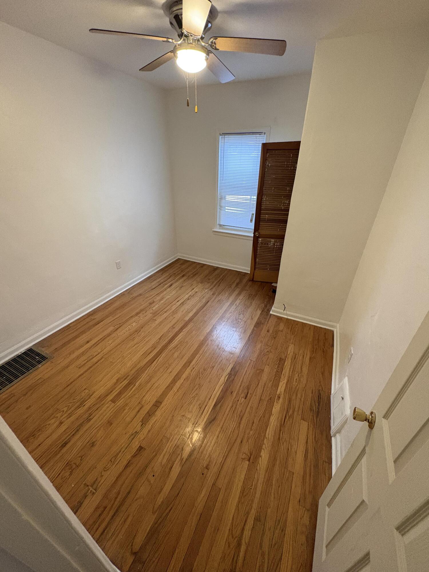 2371 Monroe Street Gary, IN 46407 - Photo 5 of 17 an empty room with wooden floor fan and windows