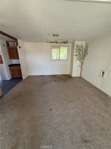 an empty room with windows and fireplace