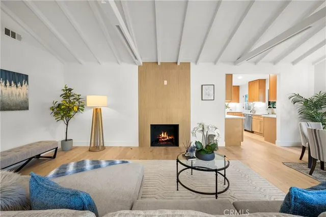 a living room with furniture a large window with kitchen view