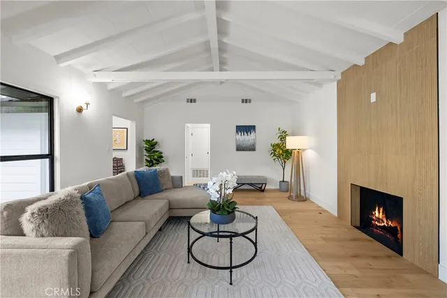 a living room with furniture kitchen view and a large window