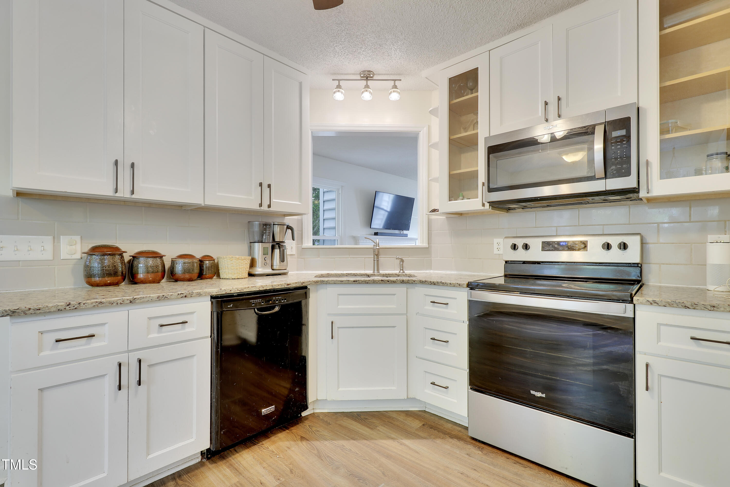4711 Buttonbush Drive Durham, NC 27712 - Photo 11 of 43 a kitchen with granite countertop white cabinets stainless steel appliances and sink