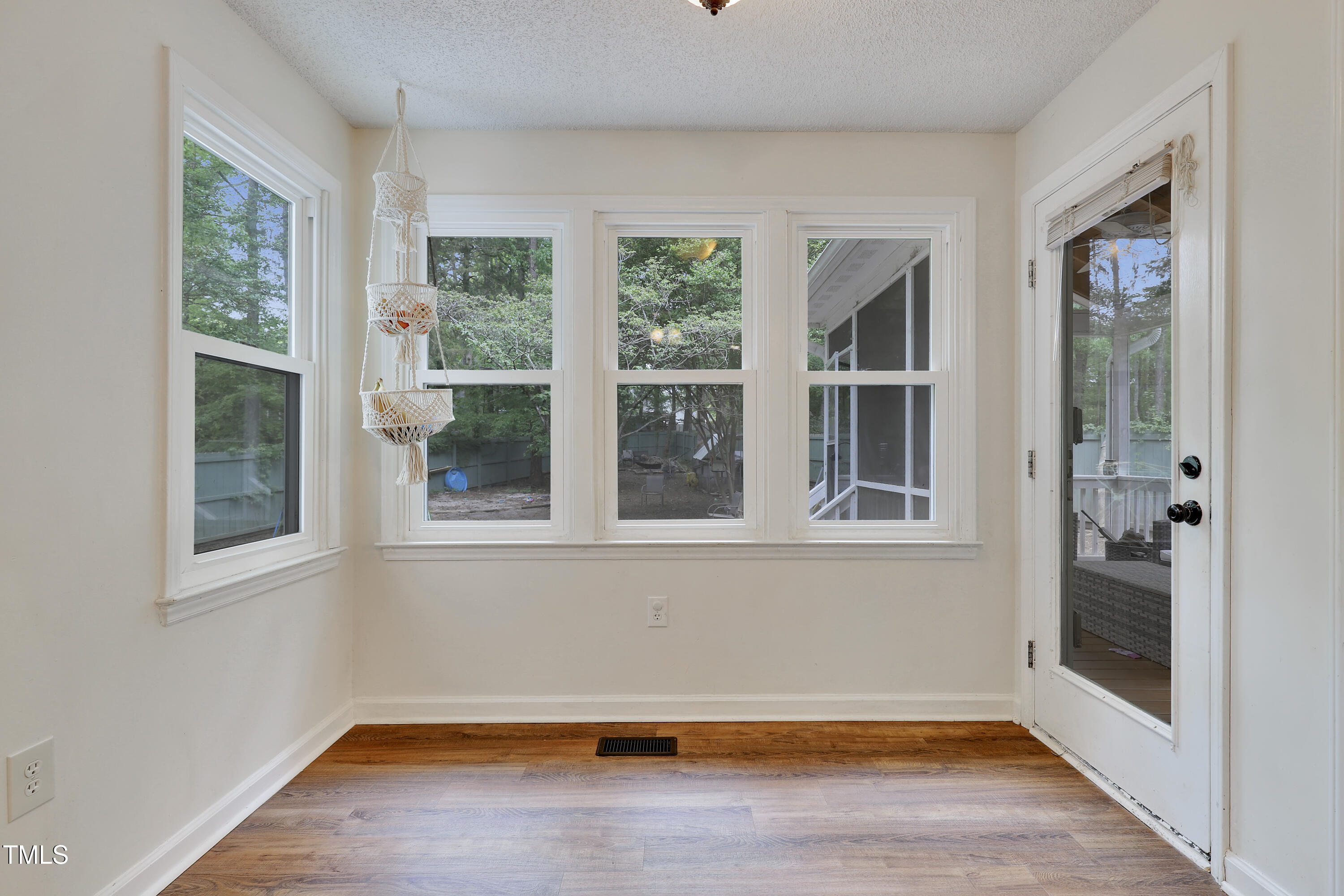 4711 Buttonbush Drive Durham, NC 27712 - Photo 14 of 43 an empty room with wooden floor and windows