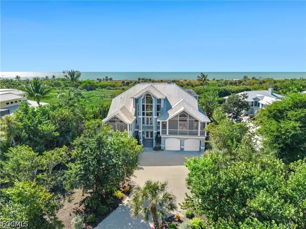 an aerial view of a house with a yard and large trees