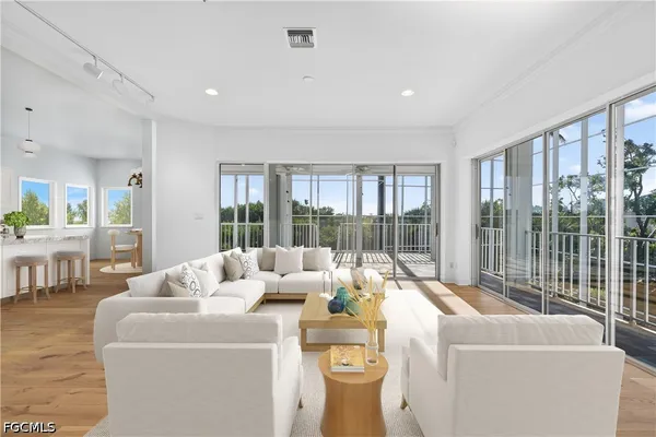 a living room with furniture large window and wooden floor