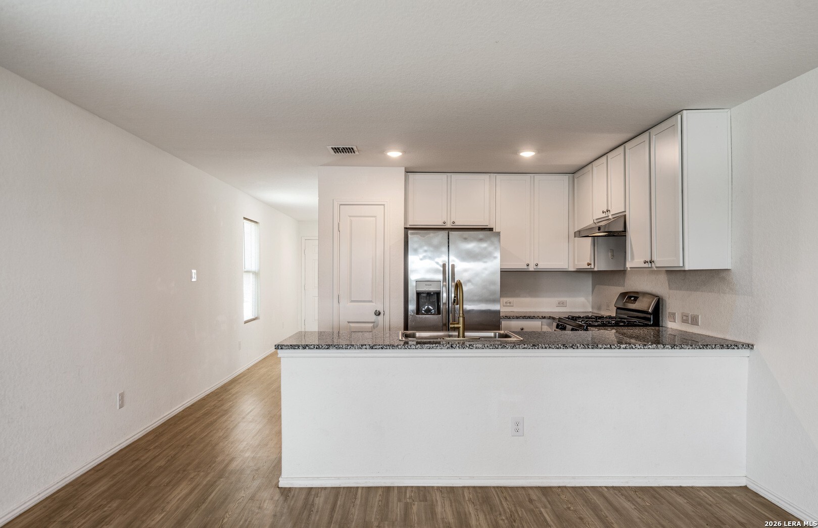 6566 Runaway Row Converse, TX 78109 - Photo 9 of 27 a kitchen with stainless steel appliances granite countertop a sink a stove a refrigerator and white cabinets