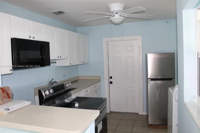 a kitchen with a sink and a stove top oven with wooden floor