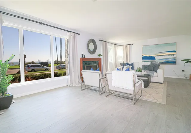 a living room with furniture a flat screen tv and a floor to ceiling window