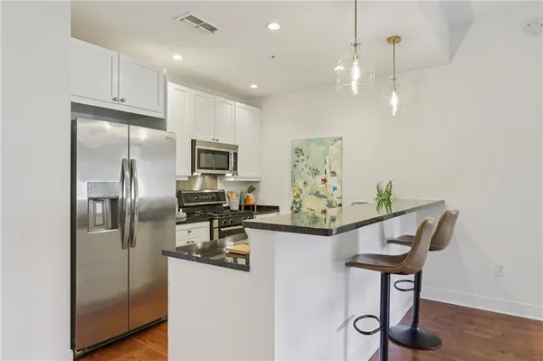 a kitchen with stainless steel appliances a stove microwave and sink