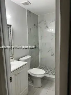 a white toilet sitting next to a bathroom sink