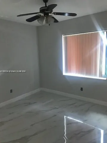 a room with a window and a ceiling fan