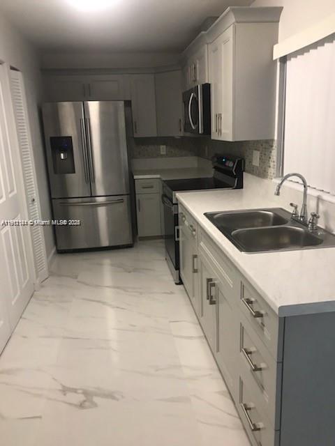 4972 Southwest 136th Place, Unit 4972 Miami, FL 33175 - Photo 10 of 24 a kitchen with stainless steel appliances a refrigerator sink and cabinets
