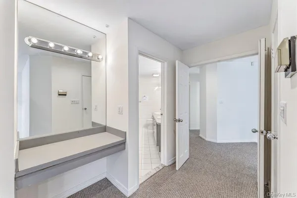 a bathroom with a granite countertop sink a toilet a mirror and bathtub