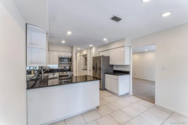 a kitchen with stainless steel appliances granite countertop a refrigerator and a sink