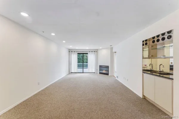 a view of empty room with kitchen