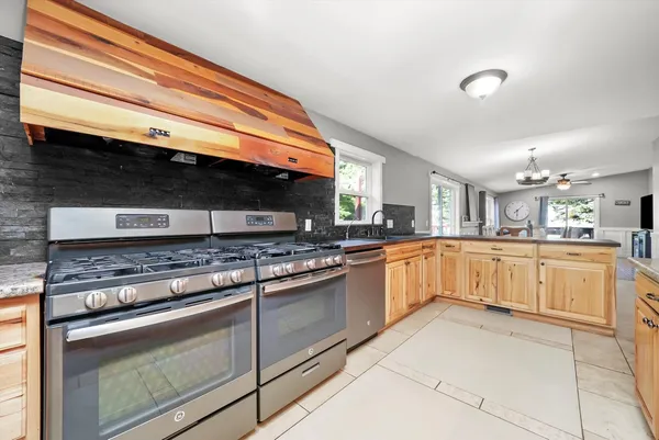 a large kitchen with stainless steel appliances granite countertop a stove and a sink