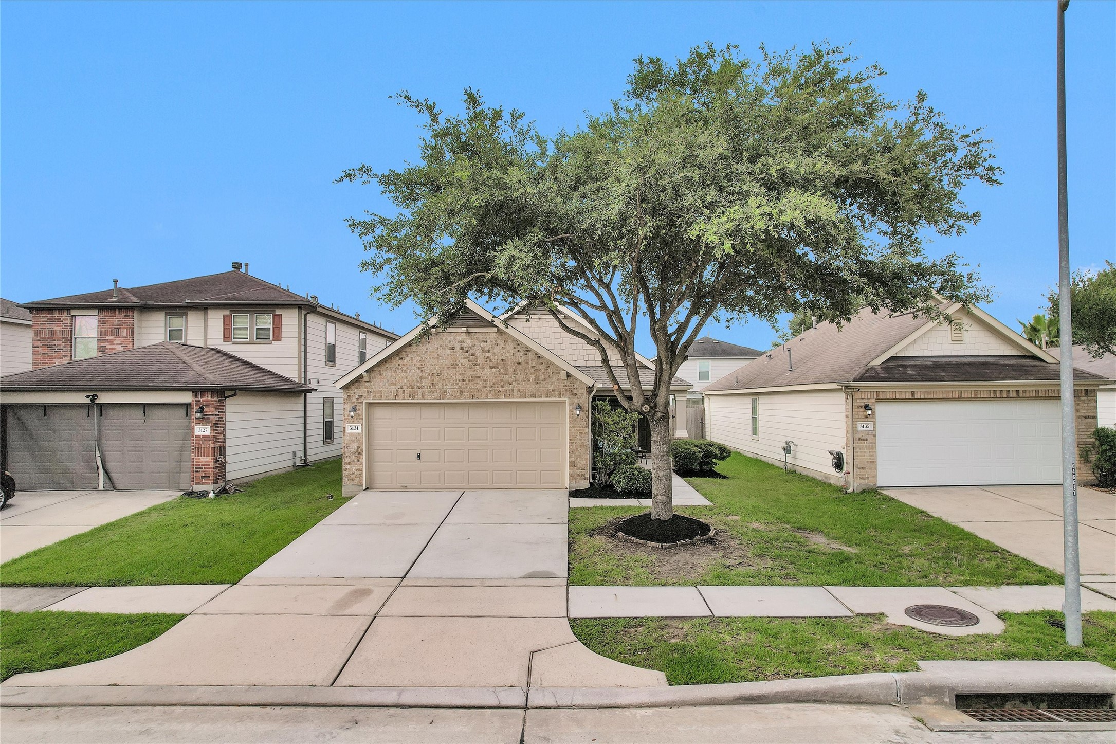 3131 Beacon Grove Street Spring, TX 77389 - Photo 2 of 38 a front view of a house with a garden and trees