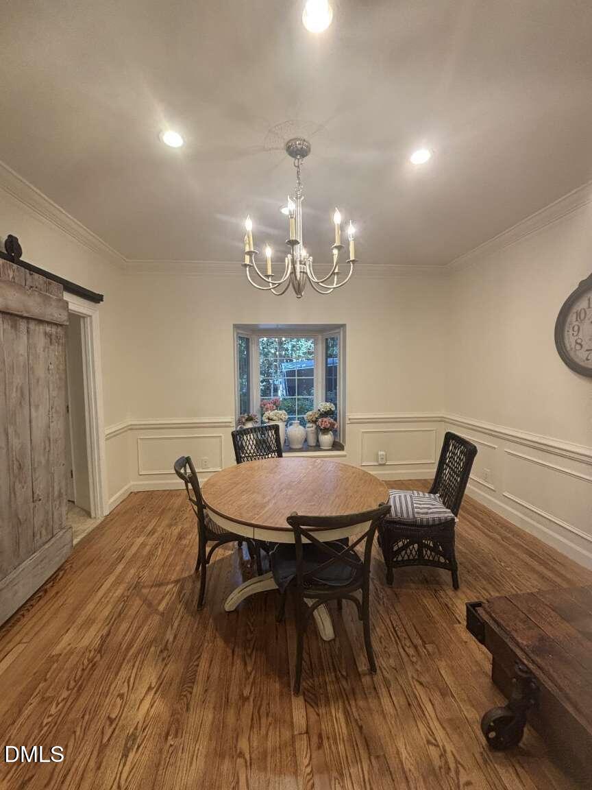 1204 Queensferry Road Cary, NC 27511 - Photo 16 of 50 a view of a dining room with furniture a chandelier and wooden floor