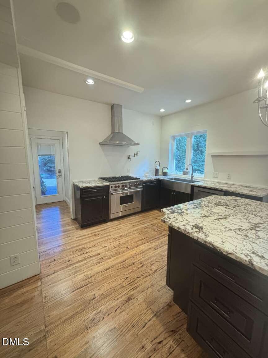1204 Queensferry Road Cary, NC 27511 - Photo 44 of 50 a large kitchen with stainless steel appliances kitchen island a large counter top and a wooden floors