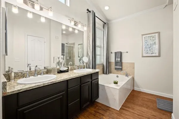 a bathroom with a double vanity sink a mirror and a bathtub