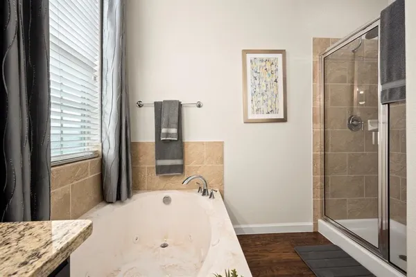 a bathroom with a granite countertop sink a mirror and shower