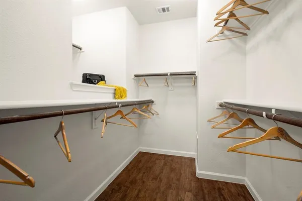 a view of walk in closet with clothes and shoes