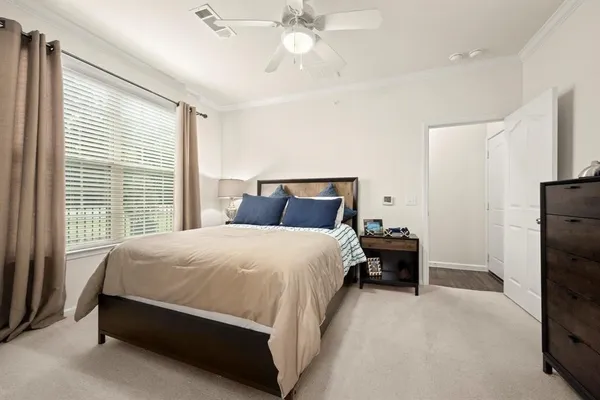 a large bed sitting in a bedroom next to a window and a chandelier
