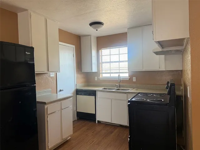a kitchen with a sink a refrigerator a stove and cabinets