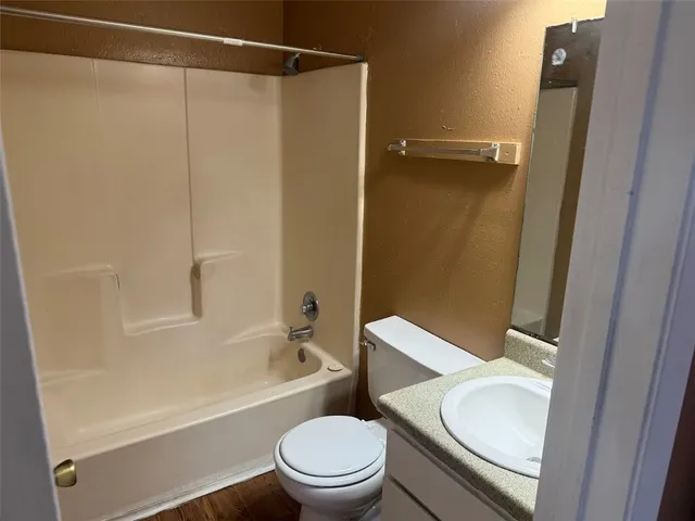 a white toilet sitting next to a bath tub