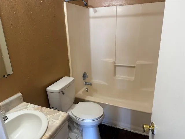 a white toilet sitting next to a bathroom sink