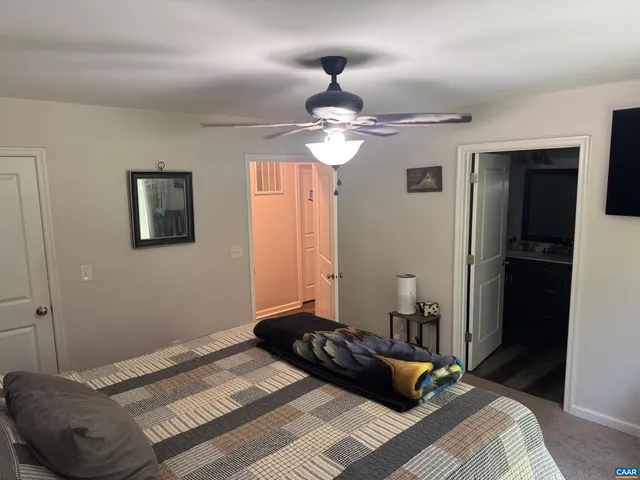a bedroom with a bed a couch and a flat screen tv