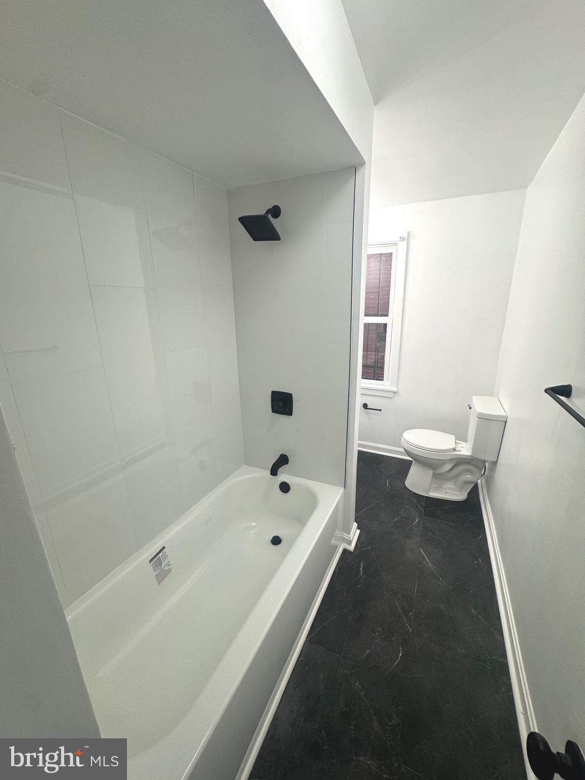 31 South Arlington Avenue Baltimore, MD 21223 - Photo 4 of 10 a bathroom with a bathtub shower sink and toilet