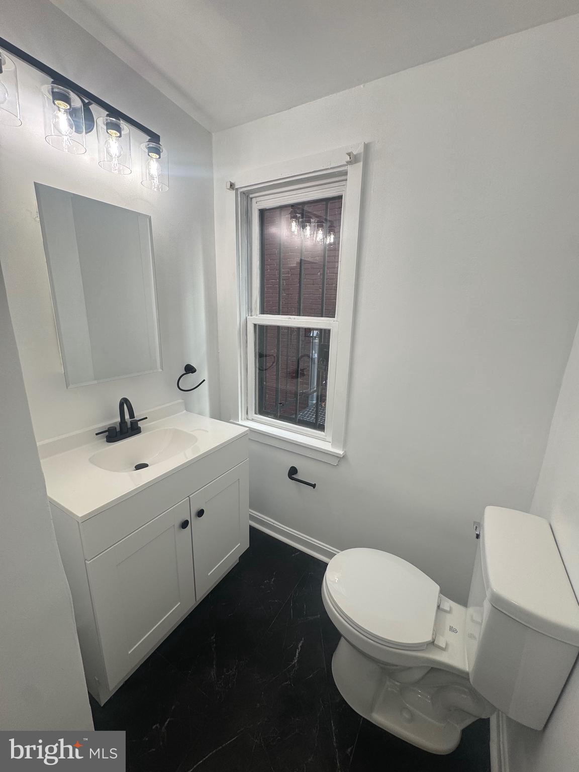 31 South Arlington Avenue Baltimore, MD 21223 - Photo 5 of 10 a bathroom with a toilet a sink and mirror