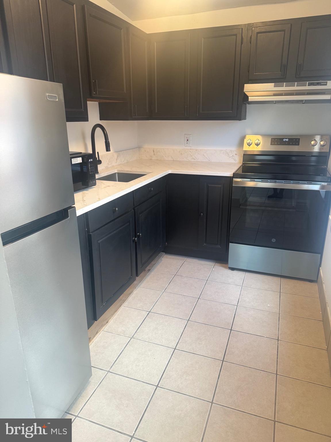 31 South Arlington Avenue Baltimore, MD 21223 - Photo 6 of 10 a kitchen with a sink a stove and cabinets