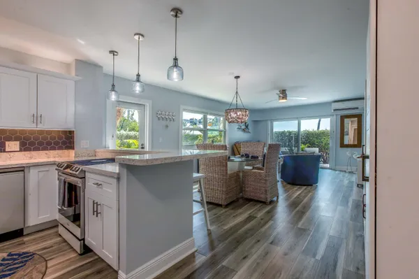 a dining room with furniture a chandelier and wooden floor