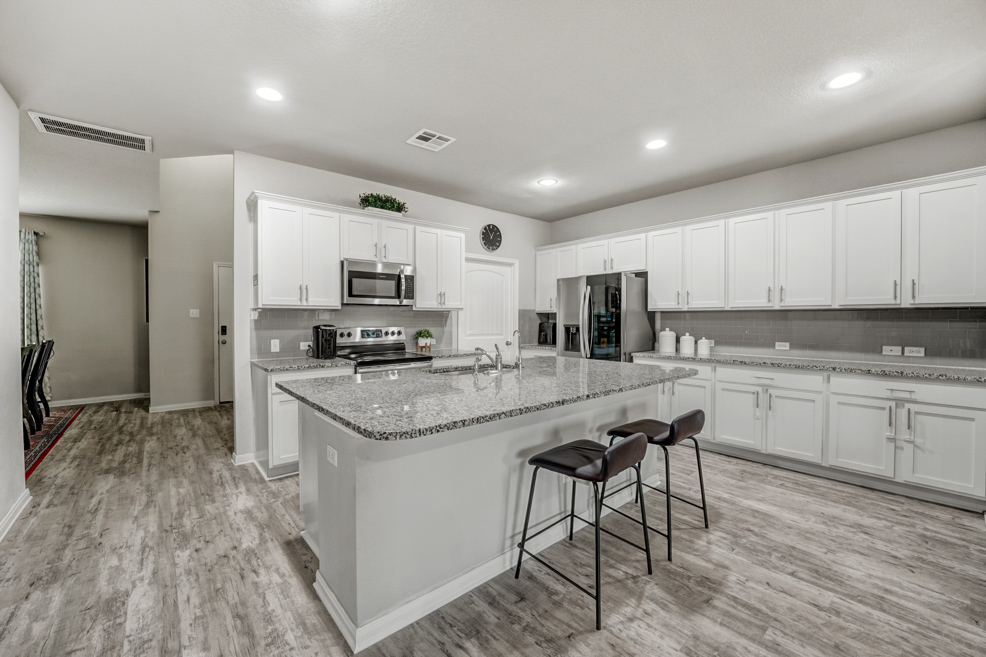 633 Donegal Lane Georgetown, TX 78626 - Photo 11 of 21 a kitchen with granite countertop kitchen island white cabinets and stainless steel appliances