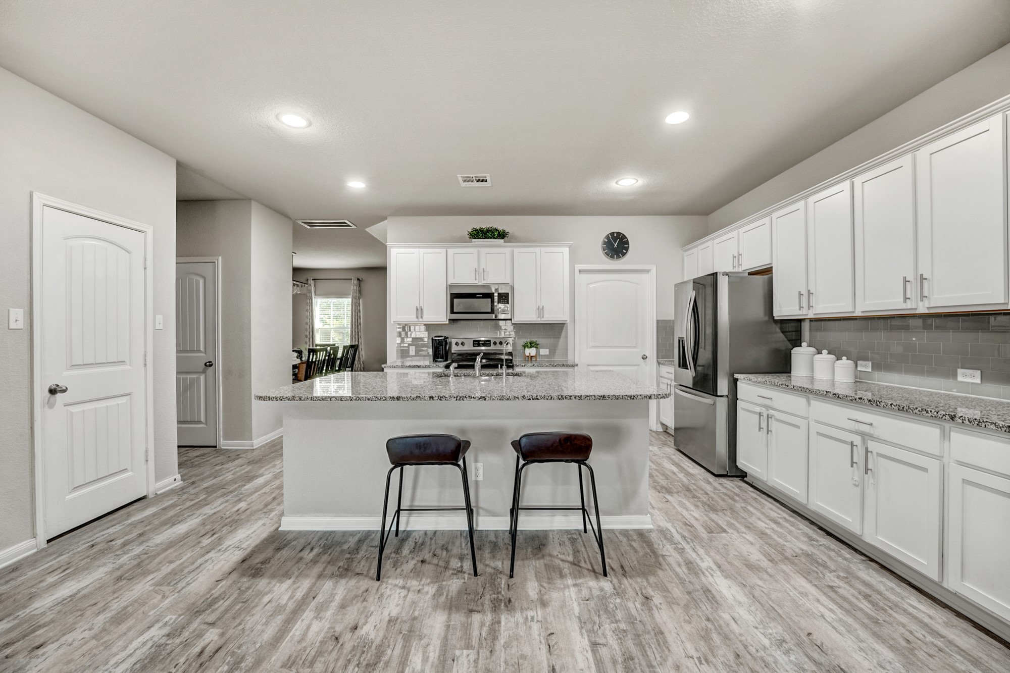 633 Donegal Lane Georgetown, TX 78626 - Photo 9 of 21 a kitchen with stainless steel appliances granite countertop a stove a sink a refrigerator and white cabinets with wooden floor