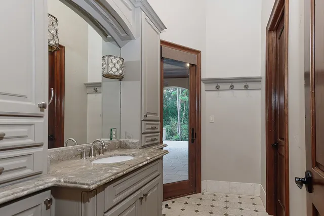 a bathroom with a granite countertop sink and a mirror