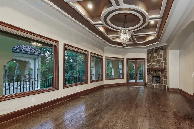 a very nice looking room with wooden floor and windows