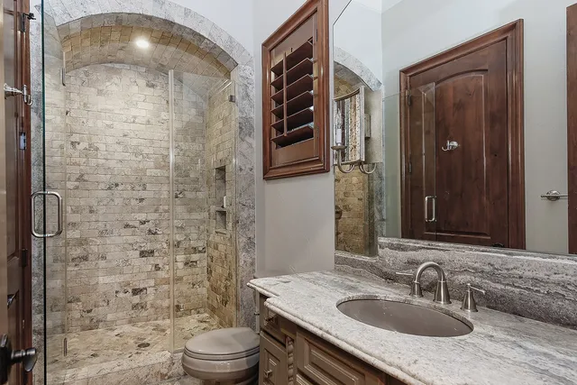 a bathroom with a sink a toilet and shower