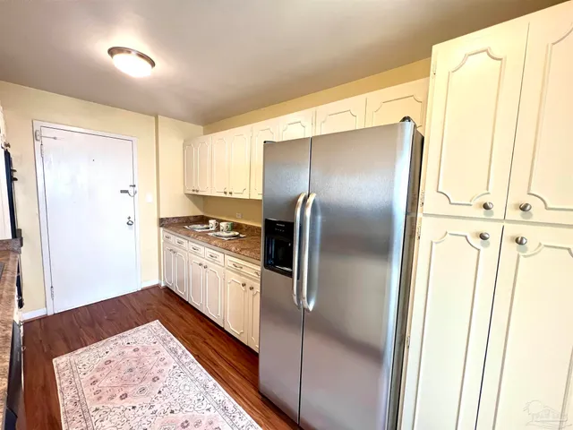 a kitchen with granite countertop stainless steel appliances a refrigerator and cabinets