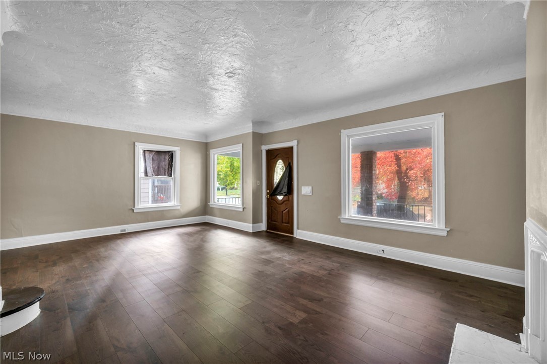 1677 Carlyon Road East Cleveland, OH 44112 - Photo 15 of 41 Entryway featuring dark wood-style floors and a textured ceiling