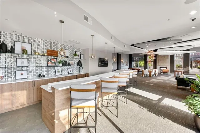 a dining hall with stainless steel appliances kitchen island granite countertop a table and chairs
